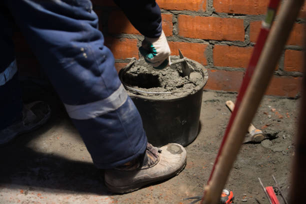 istock professional construction worker laying bricks and building barbecue in industrial site. Detail of hand adjusting 1135499847