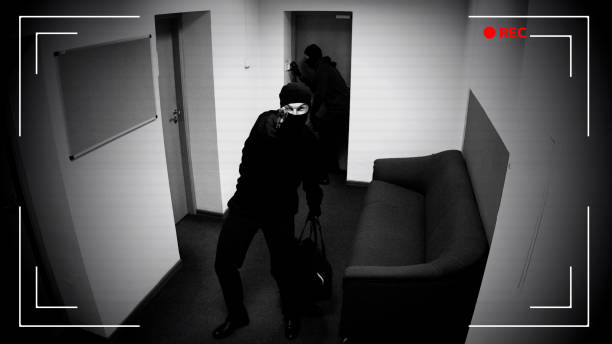 istock Two men with guns breaking in apartment, pointing weapon at surveillance camera 1135499868