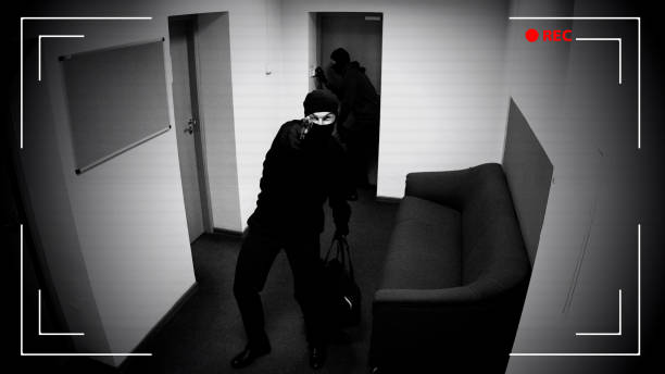 dwóch mężczyzn z bronią łamiącą się w mieszkaniu, wskazując broń na kamerę monitoringu - shot glass audio zdjęcia i obrazy z banku zdjęć