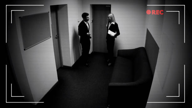 Male and female colleagues talking office corridor, CCTV camera effect, footage Male and female colleagues talking office corridor, CCTV camera effect, footage surveillance photos stock pictures, royalty-free photos & images