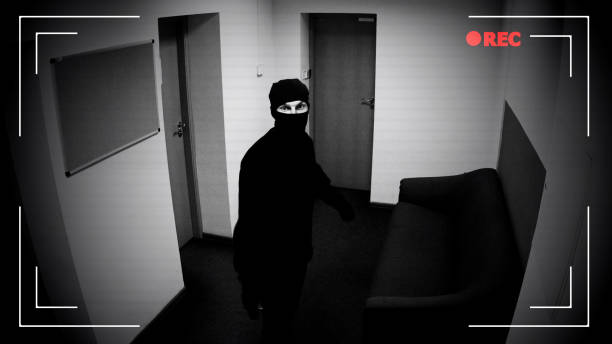 istock Robber in mask looking surveillance camera, corporative building protection 1135499878