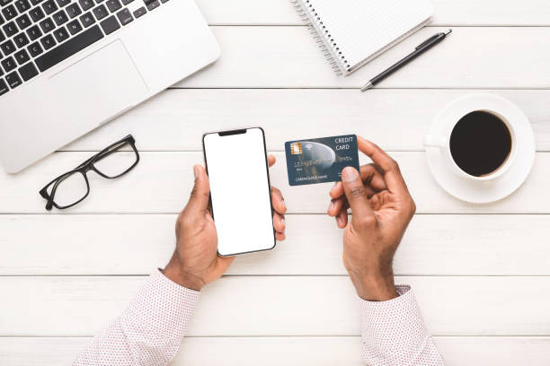 istock Man's hands holding blank smartphone and credit card 1135500357