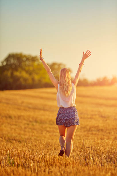 istock Young woman jumping and running in a wheat field. 1135501708
