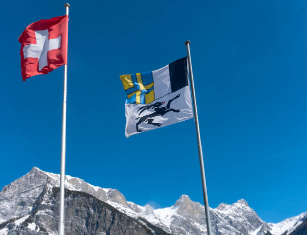 flagi szwajcarii i kantonu grisons wiejący na wietrze na błękitnym niebie w górach - graubunden canton obrazy zdjęcia i obrazy z banku zdjęć