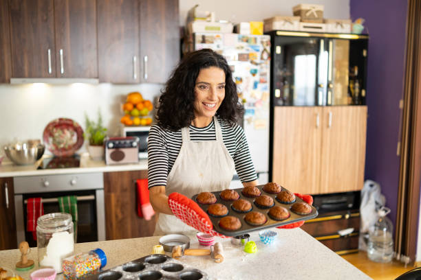 istock Smiling mother having fun with homemade muffins 1135504354