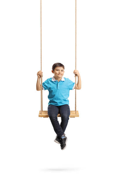 istock Happy little boy sitting on a swing and looking at the camera 1135504579