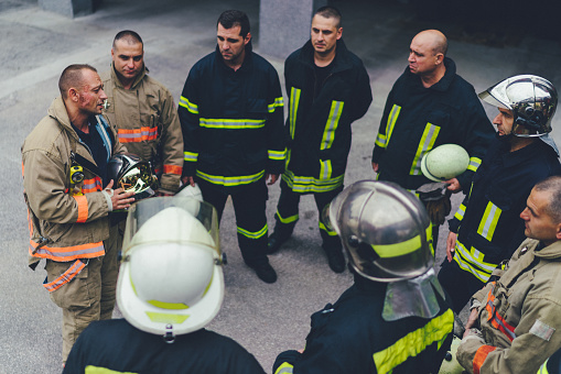 Group of real firefighters on training standing in circle