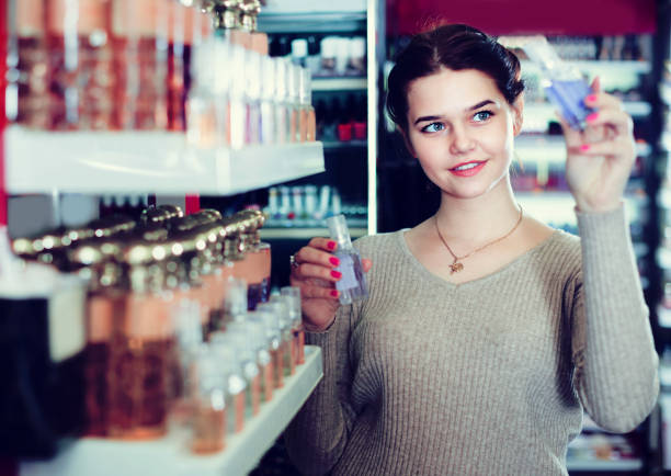 istock Young girl customer is searching for strong perfume 1135505692