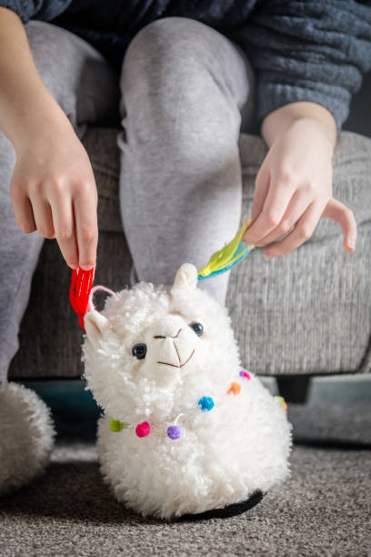 istock Young girl is wearing cute soft 3d llama slippers 1135506236