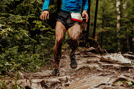 dirty athlete runner running puddles with mud splashing water