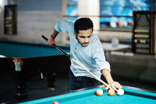 istock Stylish arabian man wear on jeans playing pool billiard on bar. 1135510568