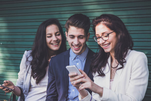 istock Happy friends browsing on their phones 1135511500