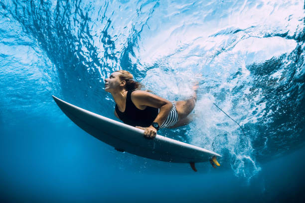 istock Surfer woman dive underwater. Surfgirl dive under big wave 1135511804