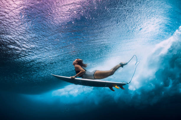 istock Surfer woman dive underwater. Surfgirl dive under big wave 1135511877