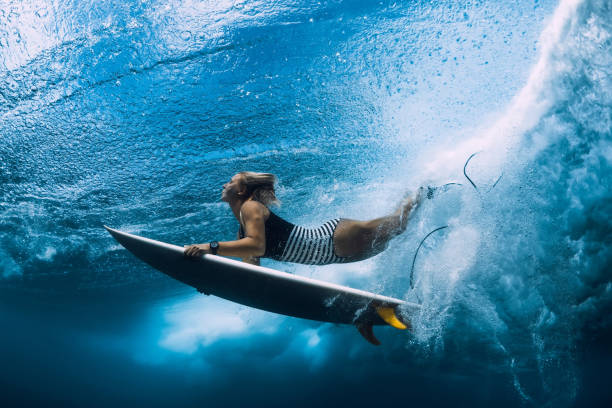 istock Surfer woman dive underwater. Surfgirl dive under big wave 1135512092
