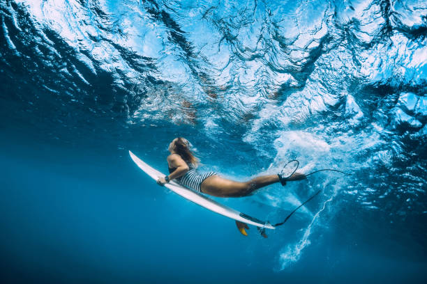 istock Surfer woman dive underwater. Surfgirl dive under big wave 1135512113