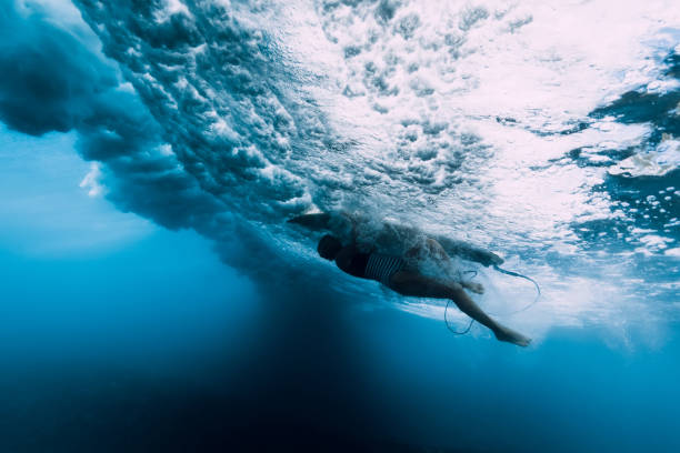 istock Surfer woman dive underwater. Surfgirl dive under big wave 1135512264