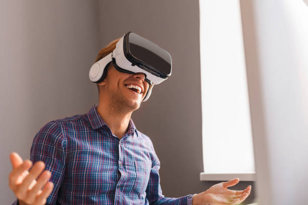 istock Cheerful man wearing VR glasses in light room 1135514267