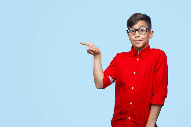 istock Funny boy in glasses pointing aside 1135514351