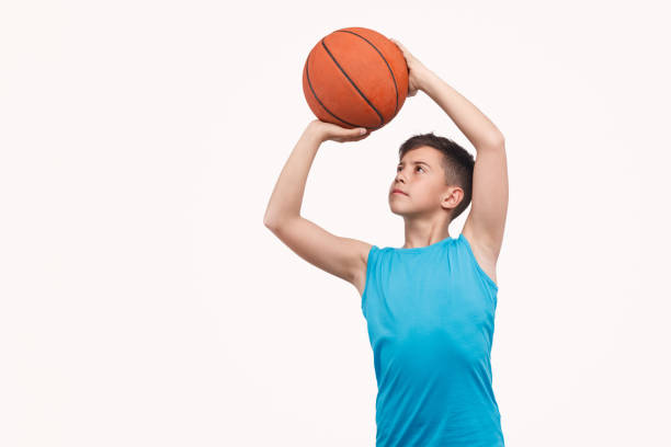 istock Boy throwing basketball ball 1135514379