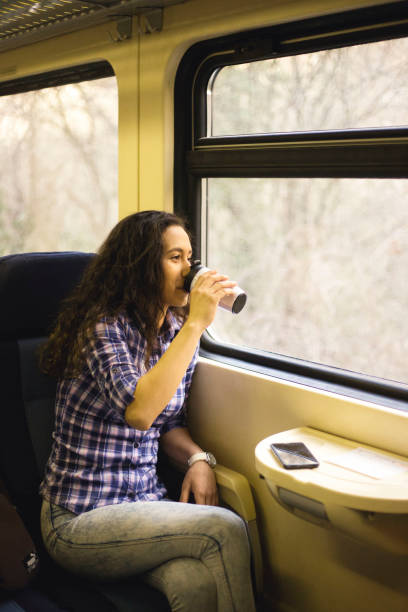 istock Young woman traveling by train and drink coffee 1135514839