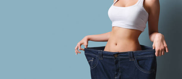 Slim girl in too big pants. Weight loss Slim girl in too big pants. Weight loss too thin stock pictures, royalty-free photos & images