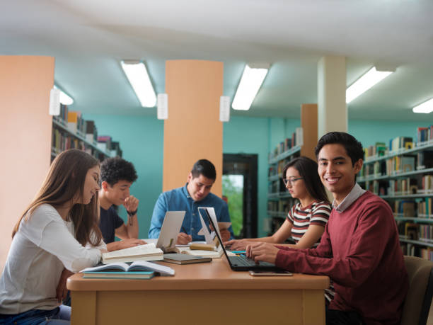 istock Smiling young man studying with a group of friends 1135517347