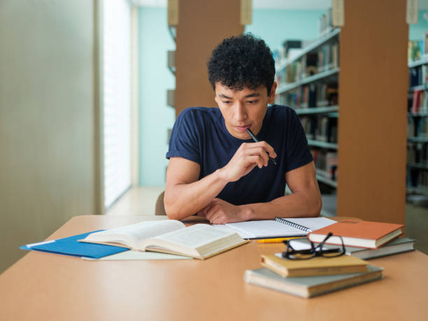 Latin college student reading a book stock photo