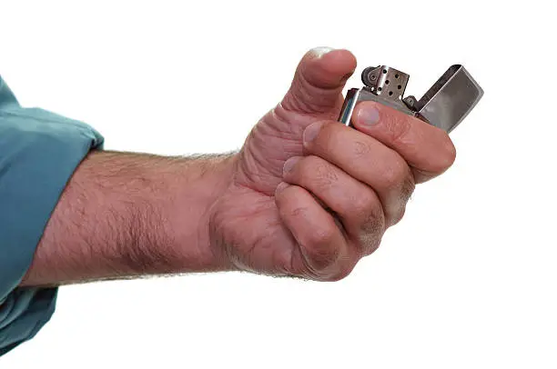 Male hand and arm, igniting a lighter/zippo.