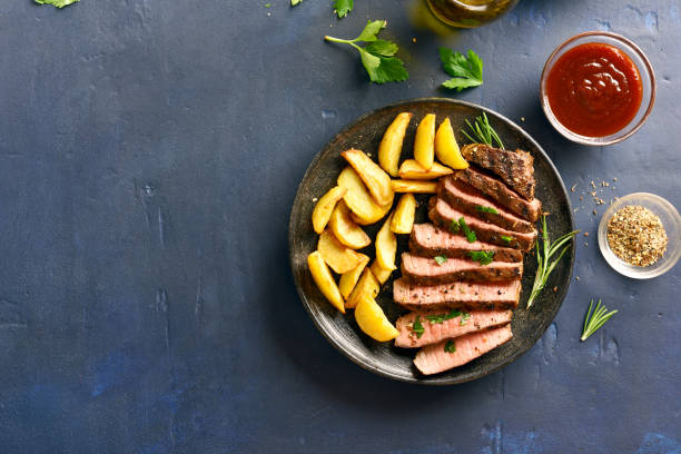 bistec medio de ternera rara con cuñas de patata - steak grilled beef plate fotografías e imágenes de stock