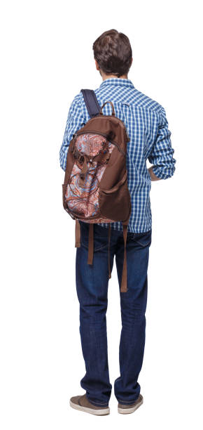 istock Back view of a student . The guy with the backpack and textbooks. 1135519964