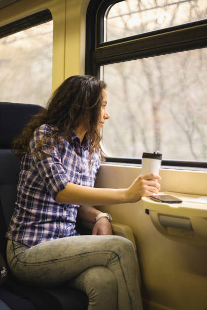 istock Young woman traveling by train and drinking coffee 1135520342