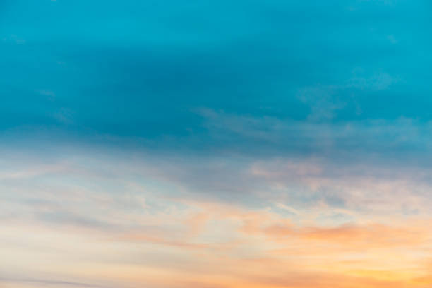 istock Sunset sky with orange yellow light clouds. Colorful smooth blue sky gradient. Natural background of sunrise. Amazing heaven at morning. Slightly cloudy evening atmosphere. Wonderful weather on dawn. 1135520552