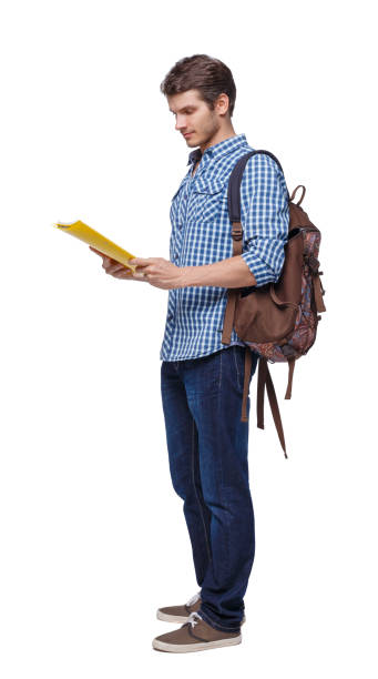 istock Side view of a student . The guy with the backpack and textbooks. 1135521665