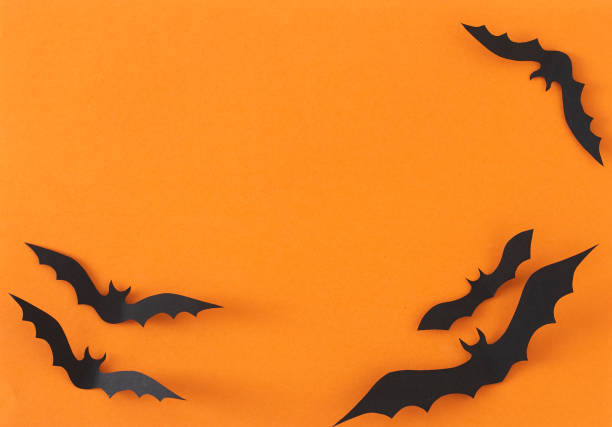 istock Paper Bats flying on orange background 1135521842