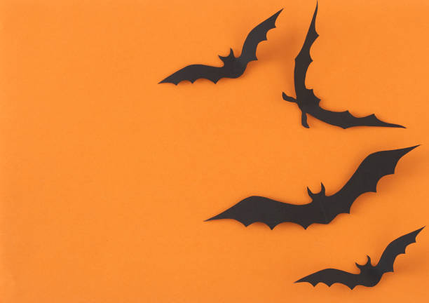 istock Paper Bats flying on orange background 1135521870