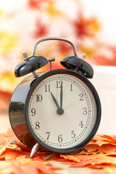 istock Old clock on autumn leaves on wooden table 1135522035