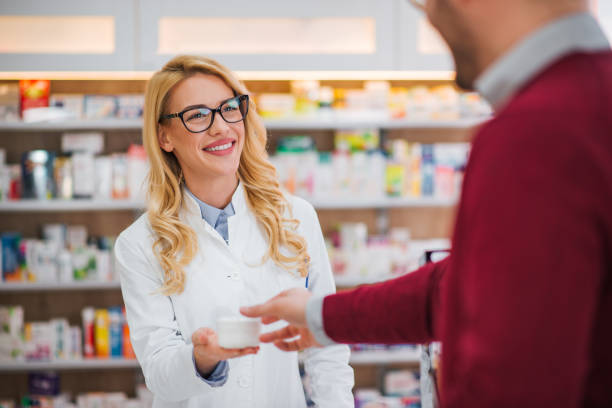 istock Smiling pharmacist giving medications to a male customer. 1135525935