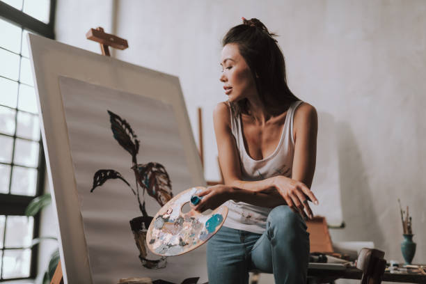 istock Calm artist putting hands on the knee and looking thoughtful 1135526451