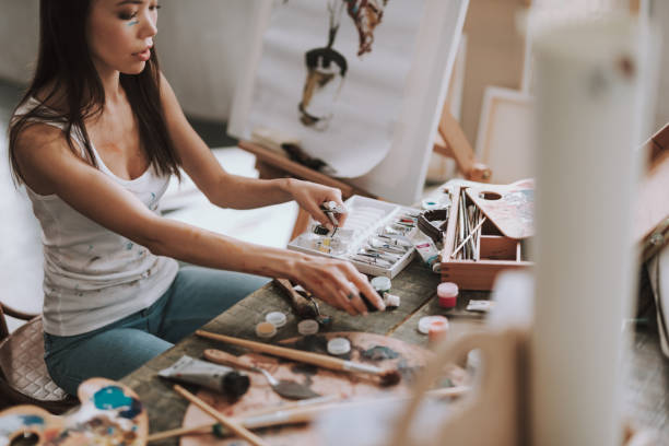 istock Calm young lady putting paints into the box 1135526476