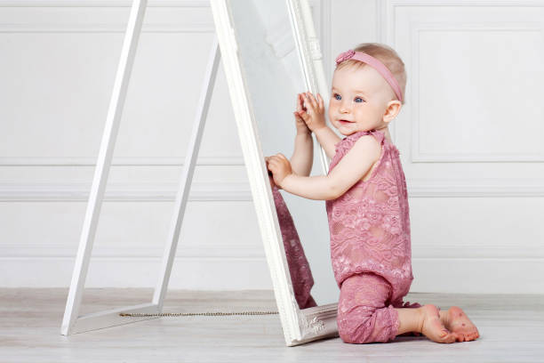 istock Little pretty girl plays with a big mirror 1135528533