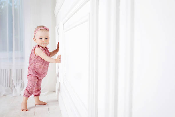 Llittle pretty girl takes the first steps. Copy space stock photo