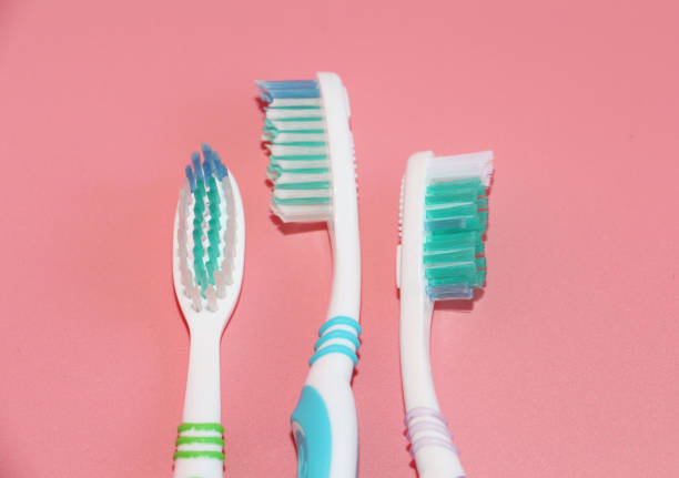 istock Three toothbrushes on a pink background. Oral hygiene. 1135529904