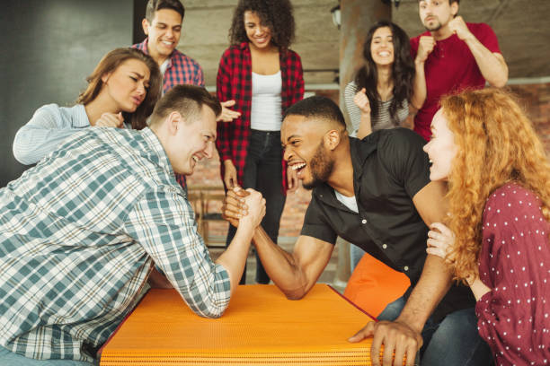istock Cheerful friends having fun arm wrestling 1135533472