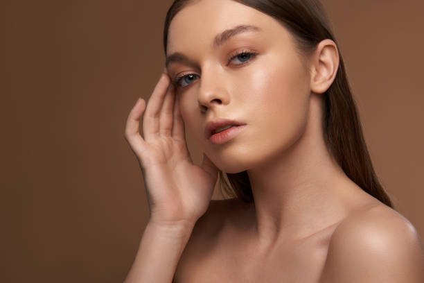 istock Beautiful lady with natural makeup keeping hand on her temple 1135533661