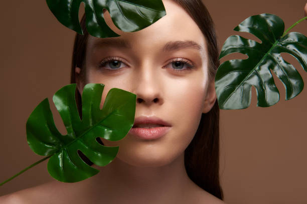 istock Beautiful girl with natural make posing with palm leaves 1135533731