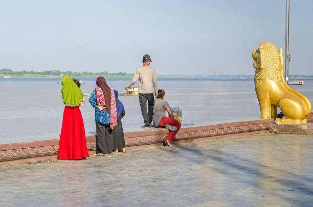 preah sisowath quay em phnom penh com a estátua do leão guardião e moradores apreciando o fim de semana - flood people asia cambodia - fotografias e filmes do acervo