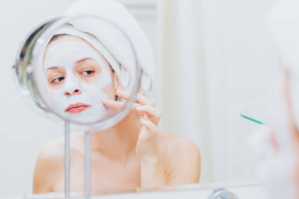 istock Young woman putting a mask on her face 1135533796