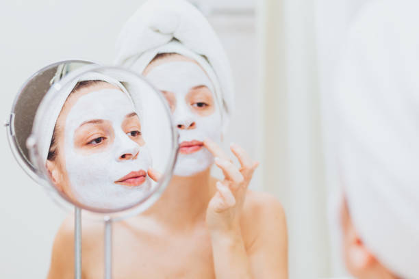 istock Young woman putting a mask on her face 1135533835