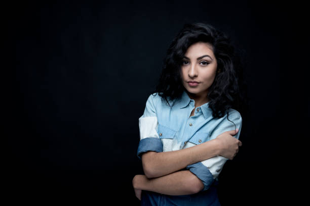 istock Good looking female with curly hair on black background 1135536436